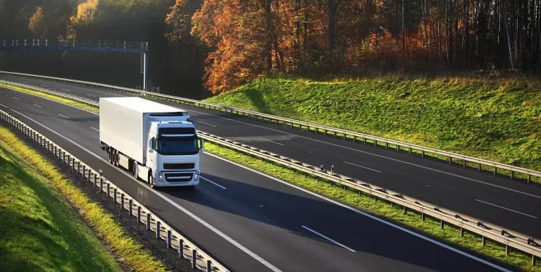 Biały ciągnik siodłowy z naczepą na autostradzie - fot. depositphotos / TC Kancelaria Prawna